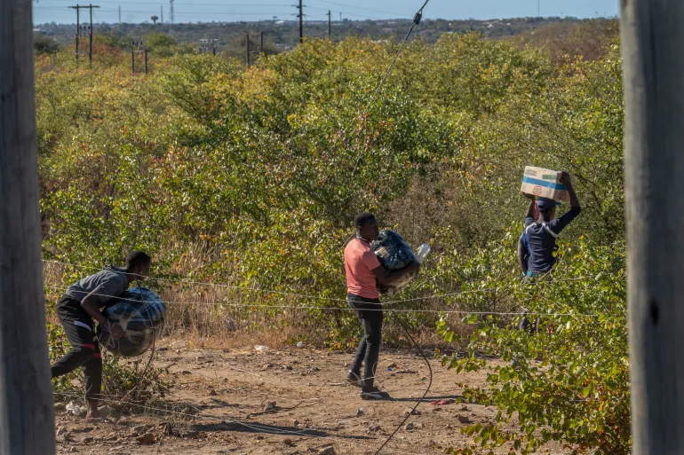 People crossing the border between South Africa and Zimbabwe near the Beitbridge border post (Source: Aljazeera, https://www.aljazeera.com/features/2024/5/15/anxious-zimbabwean-migrants-smugglers-watch-south-africas-election)